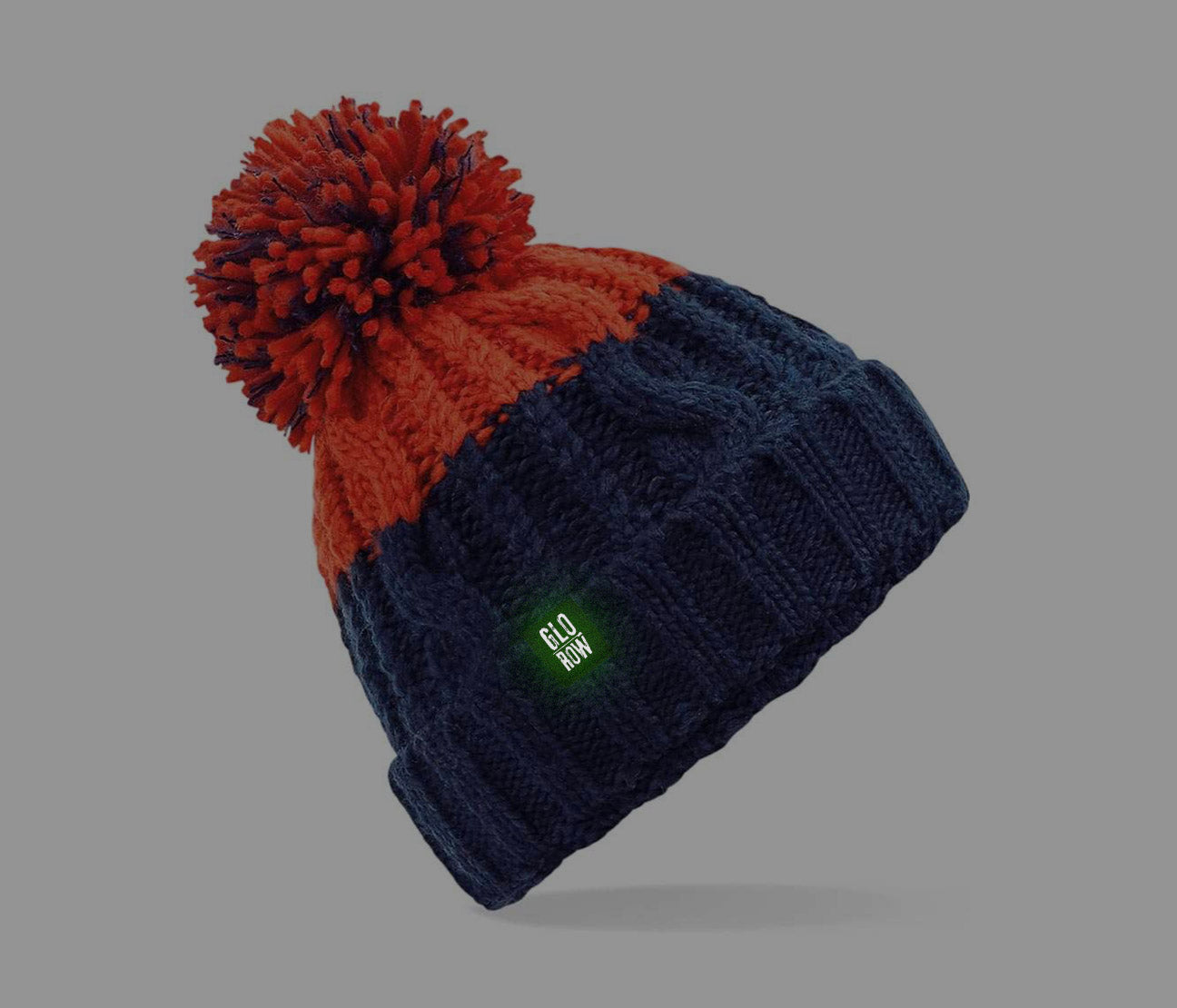 Two-tone beanie with red top and navy bottom with a glow in the dark tag