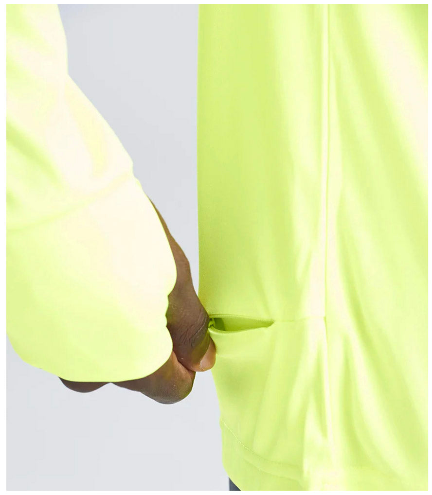 Close-up of a person wearing a bright yellow shirt with thumbholes and a pocket on a light gray background